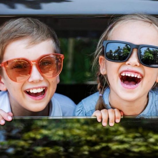 Kinder sitzend lachend im Auto